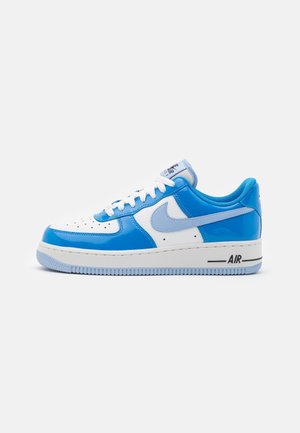 Baskets basses Nike Air Force 1 en blanc et bleu avec le swoosh bleu clair, lacets blancs et semelle bleue sur fond blanc.