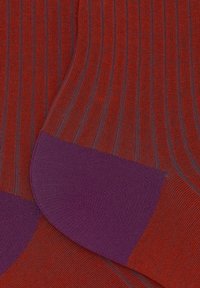 Calze rosse a costine con accenti viola sul tallone e sulla punta. La texture è liscia con sottili strisce verticali in tutto.
