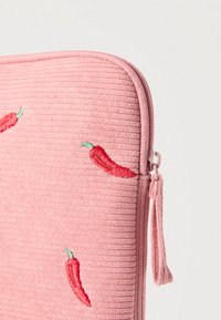 Ροζ θήκη με φερμουάρ και υφή υφάσματος, με κόκκινες κεντητές πιπεριές τσίλι και απαλό, ραβδωτό επιφάνεια.