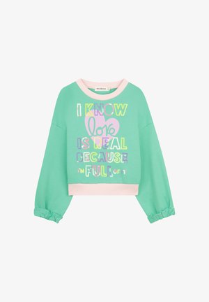 Mintgroene trui met een ronde halslijn, roze geribbelde bies en volumineuze mouwen. Voorzien van een kleurrijke tekstgrafiek in het midden aan de voorkant.