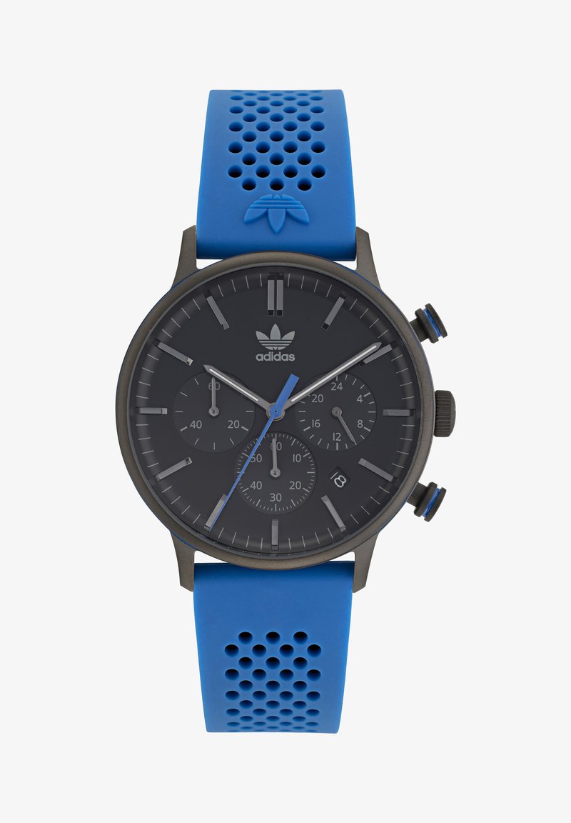 Melns hronogrāfa pulkstenis ar ziliem akcentiem, silikona siksniņa ar perforācijām un trīs subdials tumšā ciparnīcā.