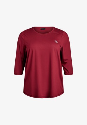 Rotes Damenoberteil mit langen Ärmeln aus glattem Stoff, mit rundem Ausschnitt und kleinem Logodetail auf der Brust. Abgerundeter Saum.