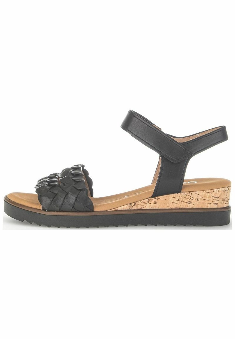 Sandal in pelle intrecciata nera con zeppa in sughero, vista laterale. Presenta una cinturino regolabile alla caviglia e una suola testurizzata per una migliore aderenza.