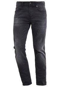 Jeans de mezclilla negra con un ajuste entallado, detalles descoloridos, diseño de cinco bolsillos, cierre con botón metálico y presillas para cinturón. Tejido suave y duradero.