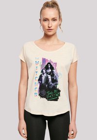 Helles beiges T-Shirt mit einem grafischen Druck von Charakteren aus "The Witcher" in Schwarz, Lila und Blaugrün, mit lockerer Passform und rundem Ausschnitt.