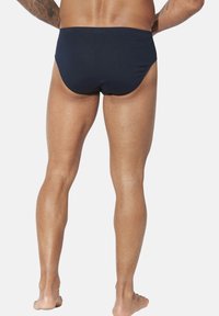 Marinefarbene Schwimmbriefe aus elastischem Material, mit einem Low-Rise-Schnitt und glatter Textur, entworfen für Komfort und Funktionalität.