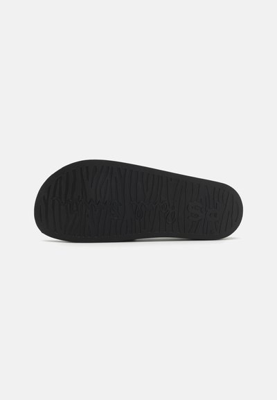 Black rubber sole with textured grip pattern, featuring raised lettering "ps" near the center. Flat, rounded edges for stability.