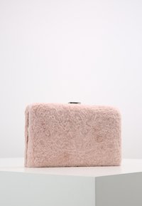 Rosa faux fur kuvertväska med rektangulär form, mjuk textur och ett silverlås på toppen. Minimalistisk design, inga ytterligare mönster.