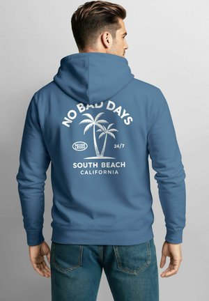 Blue hoodie featuring a kangaroo pocket and a drawstring hood. Text on back reads "NO BAD DAYS" with palm tree graphics and "SOUTH BEACH CALIFORNIA."