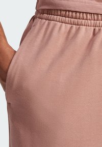 Lyserøde sweatpants med elastisk talje, sidelommer og et struktureret, blødt stof med en glat overflade.