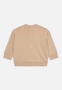 Beige bomullströja med ribbat rundhals, trekvartsärmar och ribbade fållar. Slät struktur, enkel design och utan grafiska detaljer.