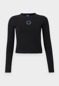 Čierna tričko s dlhým rukávom, okrúhlym výstrihom a priliehavým strihom. Na hrudi je uprostred malý logo z kryštálikov. Vyrobené z bavlny.