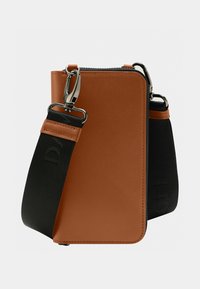 Brown synthetic bag with a smooth finish, featuring a zip closure and adjustable black strap. Silver hardware accents and logo detail present.