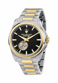 Orologio automatico con un quadrante nero texturizzato, dettagli dorati, cassa in acciaio inossidabile tono argento e maglie del bracciale alternate dorate e argento.