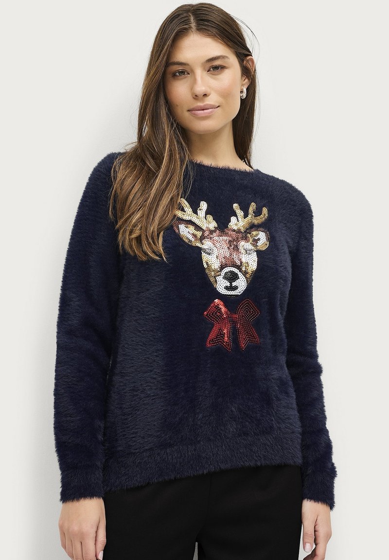 Marineblauw fleece sweater met een gestructureerde afwerking, voorzien van een met pailletten versierde rendierkop en een rode strik. Standaard ronde hals en lange mouwen.