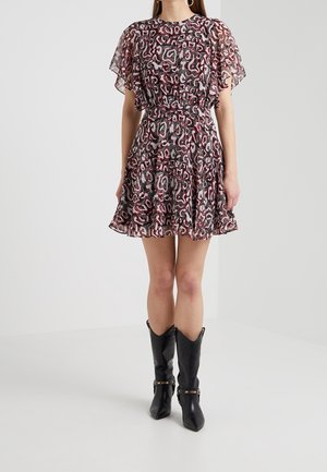 Robe à manches courtes, à motifs dans des tons de rose et de noir, avec une jupe évasée et une taille cintrée. Associée à des bottes noires montantes.