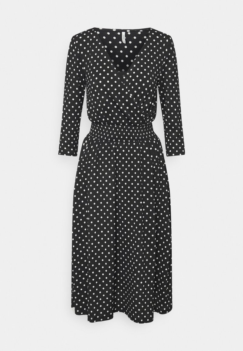 Robe noire longueur genou à pois blancs, manches trois-quarts, col en V et taille froncée.