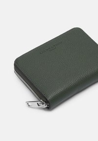 Zielony portfel ze skóry o fakturze z srebrnym zamkiem błyskawicznym. Posiada wytłoczone logo oraz zaokrąglone rogi, zapewniając zwartą, prostokątną formę.
