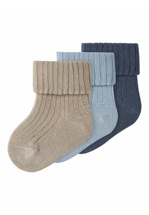 Τρία διπλωμένα πλεκτά κάλτσες με ρίγες σε μπεζ, ανοιχτό μπλε και σκούρο μπλε, τοποθετημένα επικαλυπτόμενα σε λευκό φόντο.