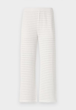 Fehér textúrájú nadrág, ami gofriszerű mintázattal rendelkezik, rugalmas derékkal és széles lábú fazonnal, a szegélyen fodros élekkel.