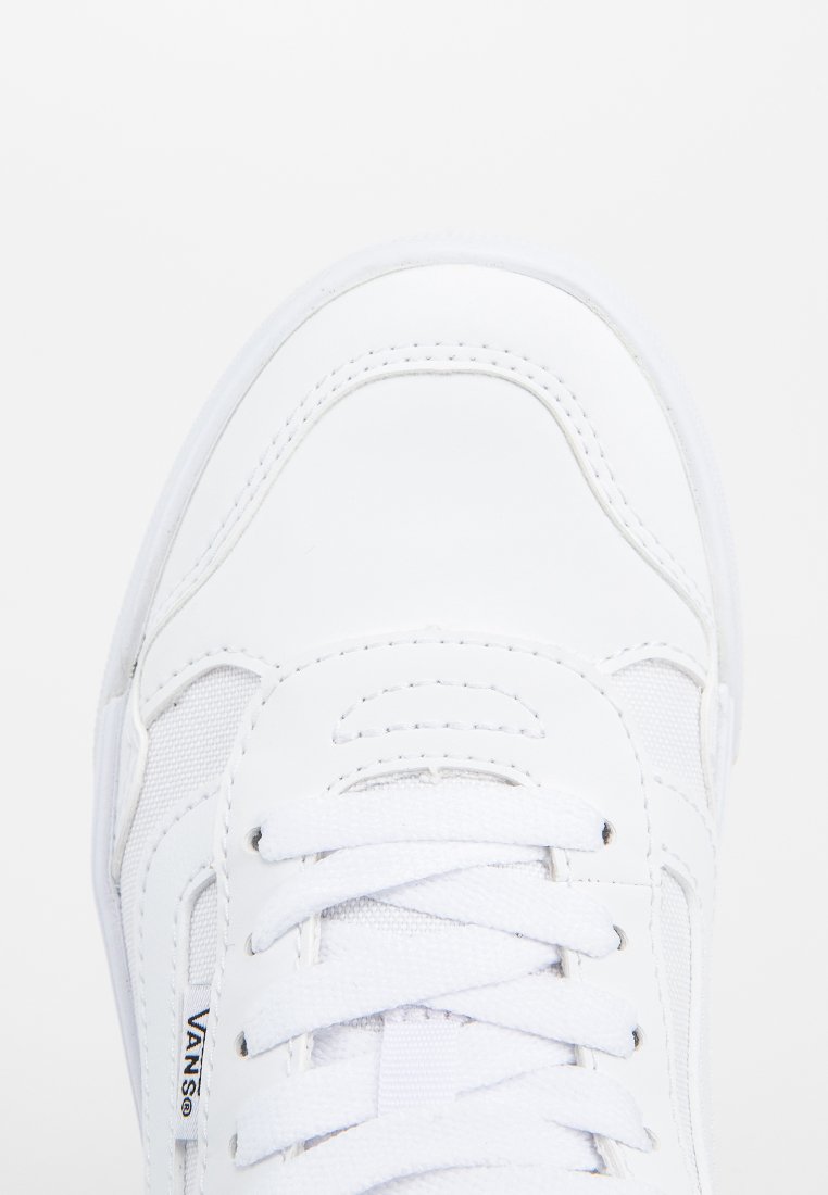 Zapatilla blanca con parte superior de cuero y tejido suave. Presenta detalles cosidos, cierre de cordones y logotipo en relieve en el lateral.