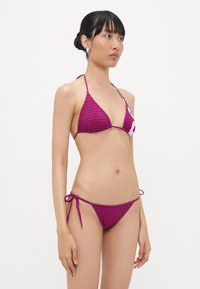 Bikini triangulaire en rose foncé avec un imprimé logo répété. Le haut a des liens ajustables et le bas présente des liens latéraux pour un ajustement parfait.