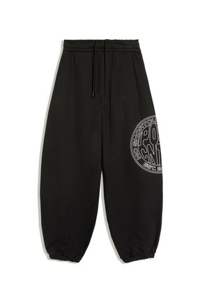 Pantalon de survêtement noir avec taille et poignets élastiques, cordon et texte graphique blanc en forme de cercle sur la cuisse droite.