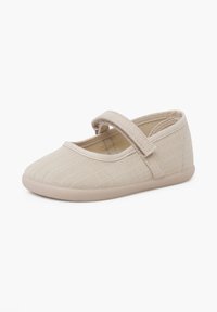 Chaussure Mary Jane beige pour tout-petit avec tige en tissu, bout arrondi et bride unique à scratch sur fond blanc.
