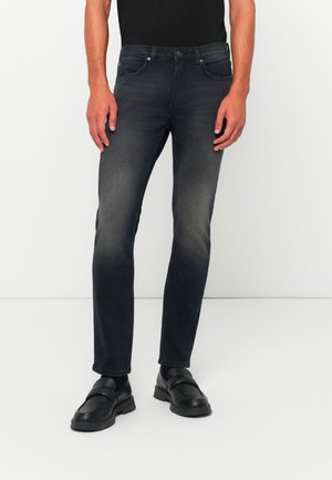 Dark blue jeans with a slim fit, featuring a faded wash, traditional five-pocket design, and subtle hardware accents.