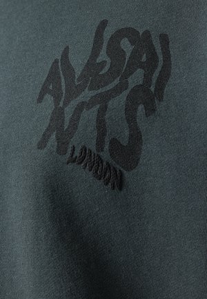 Mørkegrøn tekstil med et fremtrædende sort grafisk print af teksten "ALLSAINTS LONDON" i en stiliseret, bølget skrifttype.