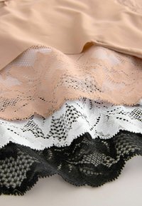 Kantafwerking in drie lagen: lichtbeige, wit en zwart. Het kant heeft ingewikkelde bloemmotieven en golvende randen. Zachte textuur.