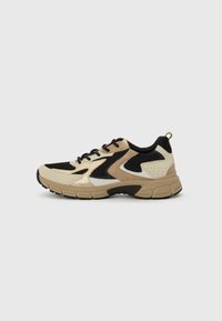 Sneaker with a cream, black, and tan color scheme. Features mesh panels, textured overlays, and a thick rubber sole with a tab at the heel.