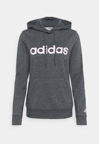 Ciemnoszara bluza z kapturem wykonana z mieszanki bawełny. Posiada duże różowe logo "adidas", przednią kieszeń kangurkę oraz kaptur ze sznurkiem. Ribbed mankiety i dół.