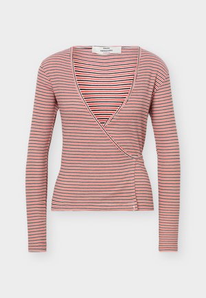 Haut à manches longues, style cache-cœur, avec des rayures horizontales rouges, noires et blanches, et un profond décolleté en V.