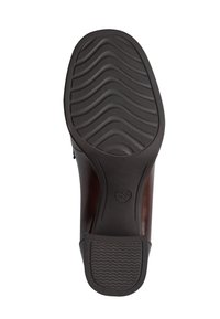 Semelle d'une chaussure habillée marron foncé montrant un motif de bande ondulée et des marquages de taille au niveau du talon et de la partie avant.