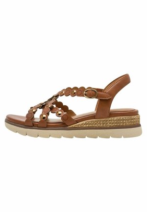 Brun læder sandal med cirkulære udskæringer, justerbar rem og en lagdelt sål. Har en tekstureret, vævet detalje ved hælen.