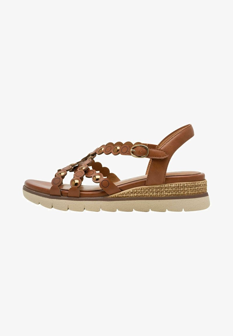 Sandale en cuir marron avec découpes circulaires, bride ajustable et semelle à couches. Présente un accent texturé tressé au niveau du talon.