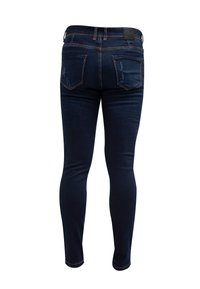 Jeans ajustados de mezclilla azul oscuro con una textura suave, cinco bolsillos y detalles de desgaste sutil. Presenta una etiqueta de cuero de la marca en la parte trasera.