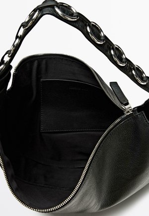 Sort læderhåndtaske med tekstureret finish, sølv lynlås og en stor kæderem. Indvendigt har den en sort foer og en kortlomme.