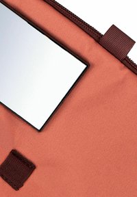 Pochette con zip in tessuto rosa polveroso, dotata di uno specchio rettangolare inserito nella parte superiore. Presenta una linguetta in tessuto marrone scuro per un'apertura facile.