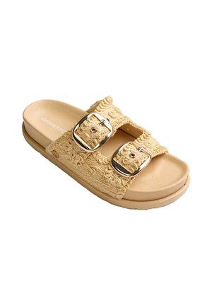 Sandalia plana beige con dos tiras de tela texturizada y hebillas plateadas ajustables en una suela plana.