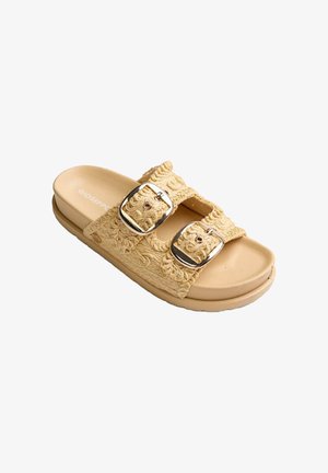 Béžová pantofle na klínu se dvěma texturovanými tkanými pásky a nastavitelnými stříbrnými přezkami na ploché podešvi.