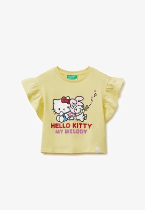 Camiseta amarilla para niños con mangas con volantes que presenta a los personajes Hello Kitty y My Melody, acompañados de notas musicales y texto.