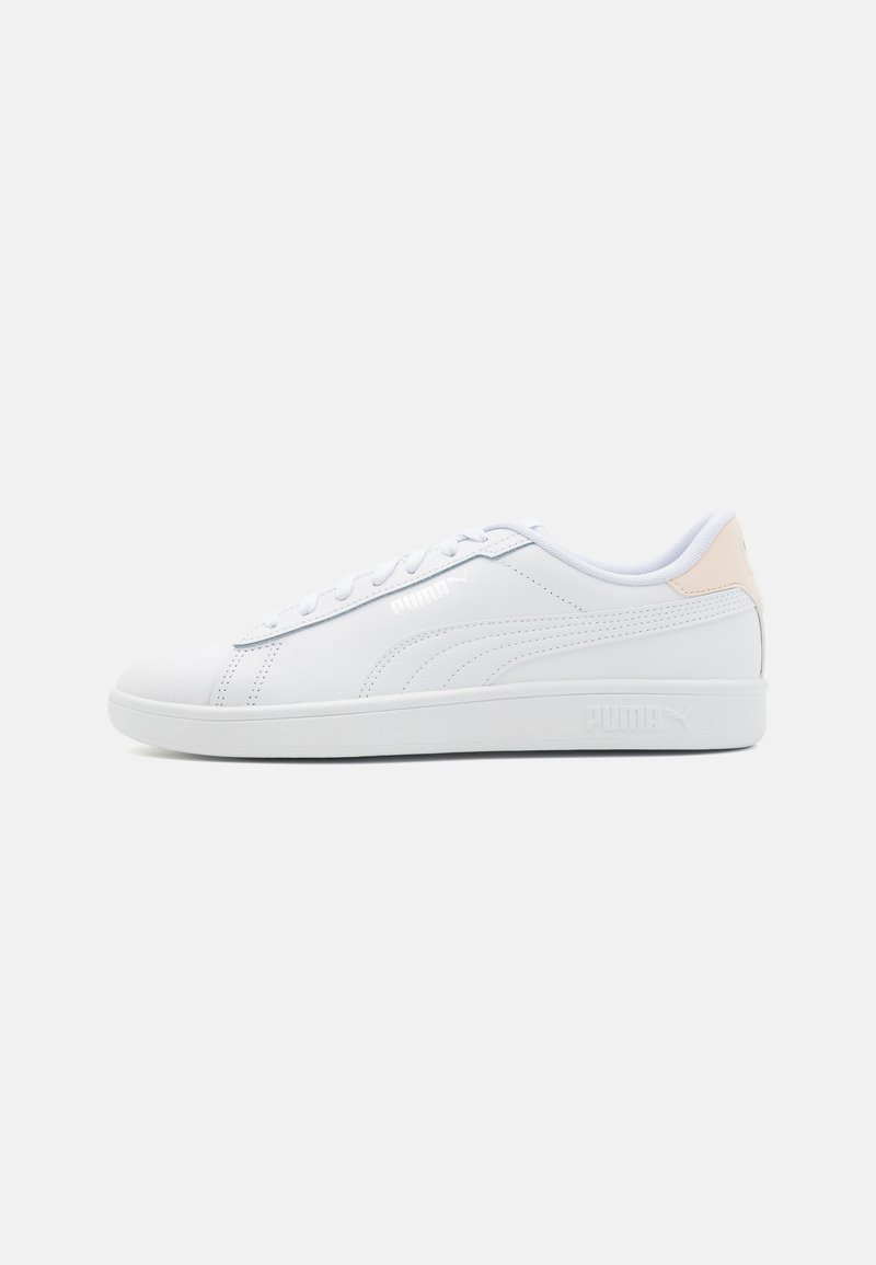 White athletic sneakers made of synthetic leather featuring a smooth texture, flat rubber sole, and subtle pink accent on the heel.