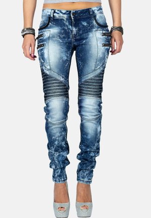 Blaue, lässig wirkende Jeans aus Denim mit Akzentnähten und gerippten Details an den Oberschenkeln. Verfügt über metallene Reißverschlusstaschen und eine schmal zulaufende Passform.