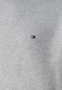 Grey cotton sweatshirt featuring a small embroidered logo with red, white, and blue accents on the left chest area.