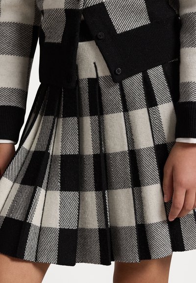 Gonna plissettata a quadri neri e grigi realizzata in tessuto testurizzato, con vita elastica e dettagli in maglia a contrasto in vita.