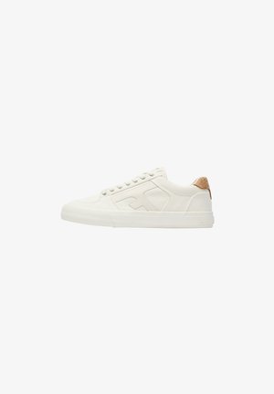 Witte lage sneakers van canvas met witte veters, een geribbelde zool en een hielstuk van beige suède, weergegeven in zijaanzicht op een witte achtergrond.