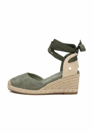 Espadrilles con cuña de ante verde oliva, suela de yute trenzado y una correa de malla con estampado en el tobillo. Cintas para el cierre atado en el tobillo.