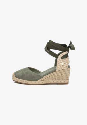 Espadrilles con cuña de ante verde oliva, suela de yute trenzado y una correa de malla con estampado en el tobillo. Cintas para el cierre atado en el tobillo.